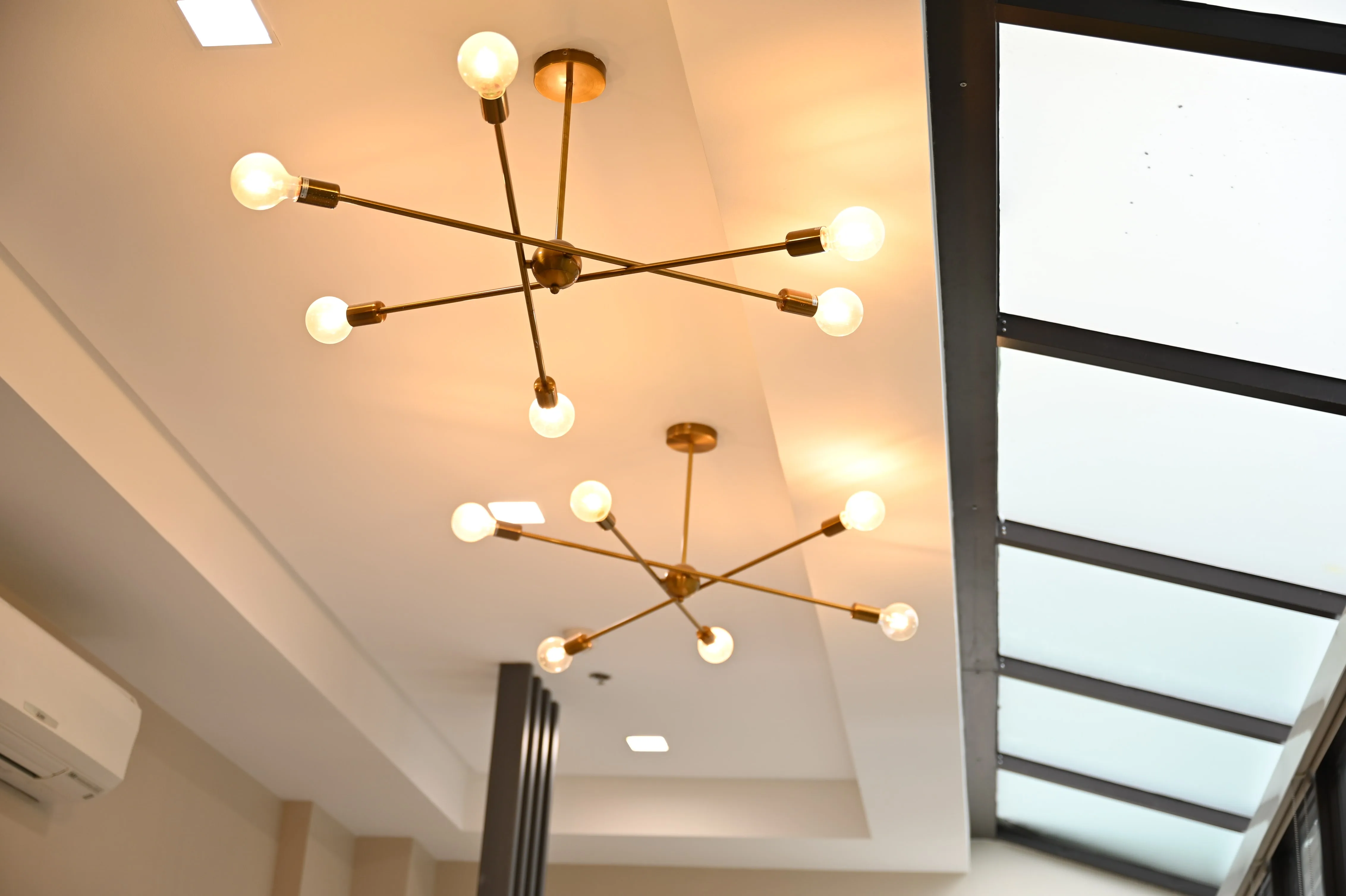 Branching pendant lights beside a skylight inside the Jubilee Center