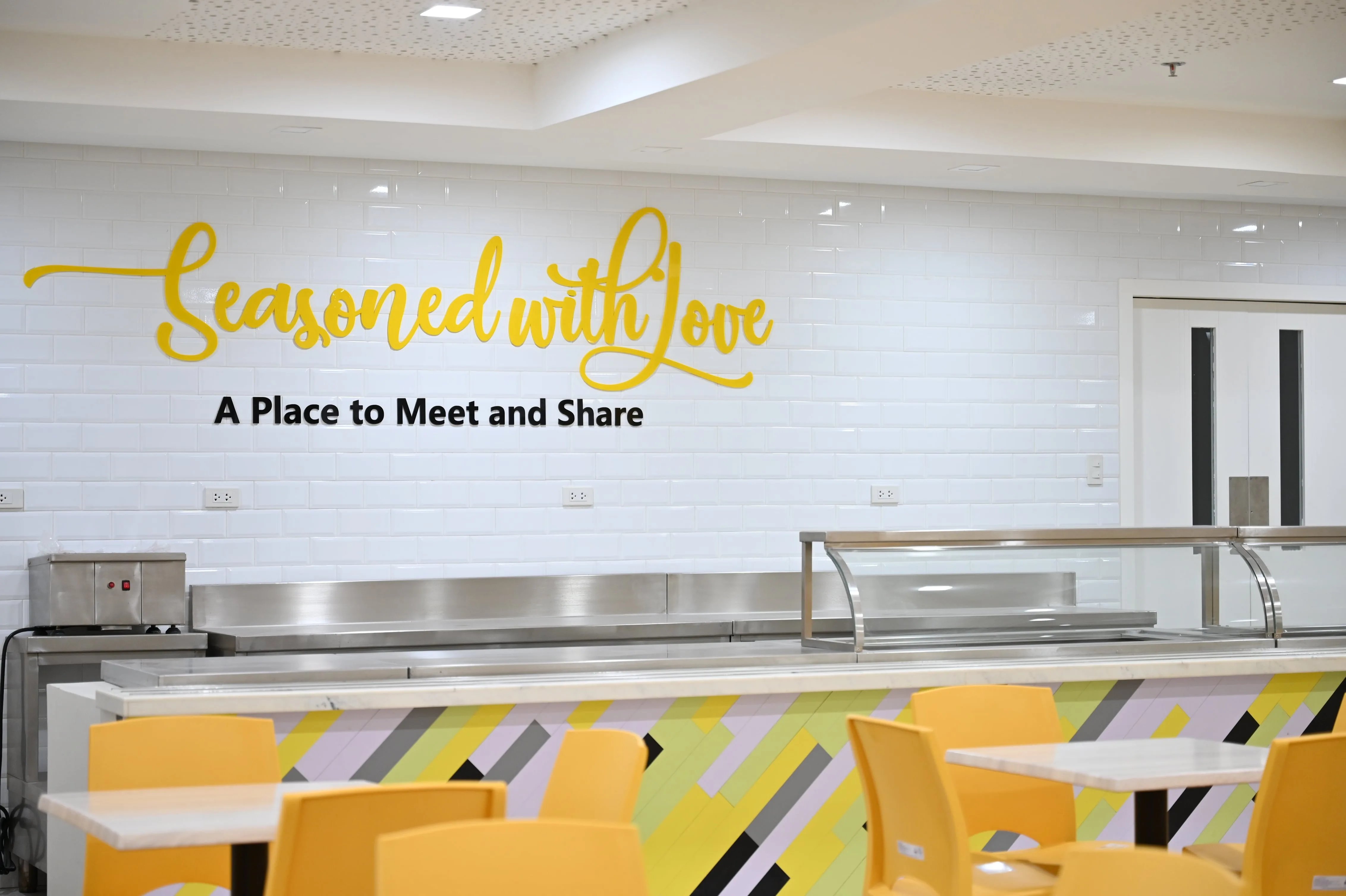 Yellow seating and serving counter inside the Jubilee Center dining hall