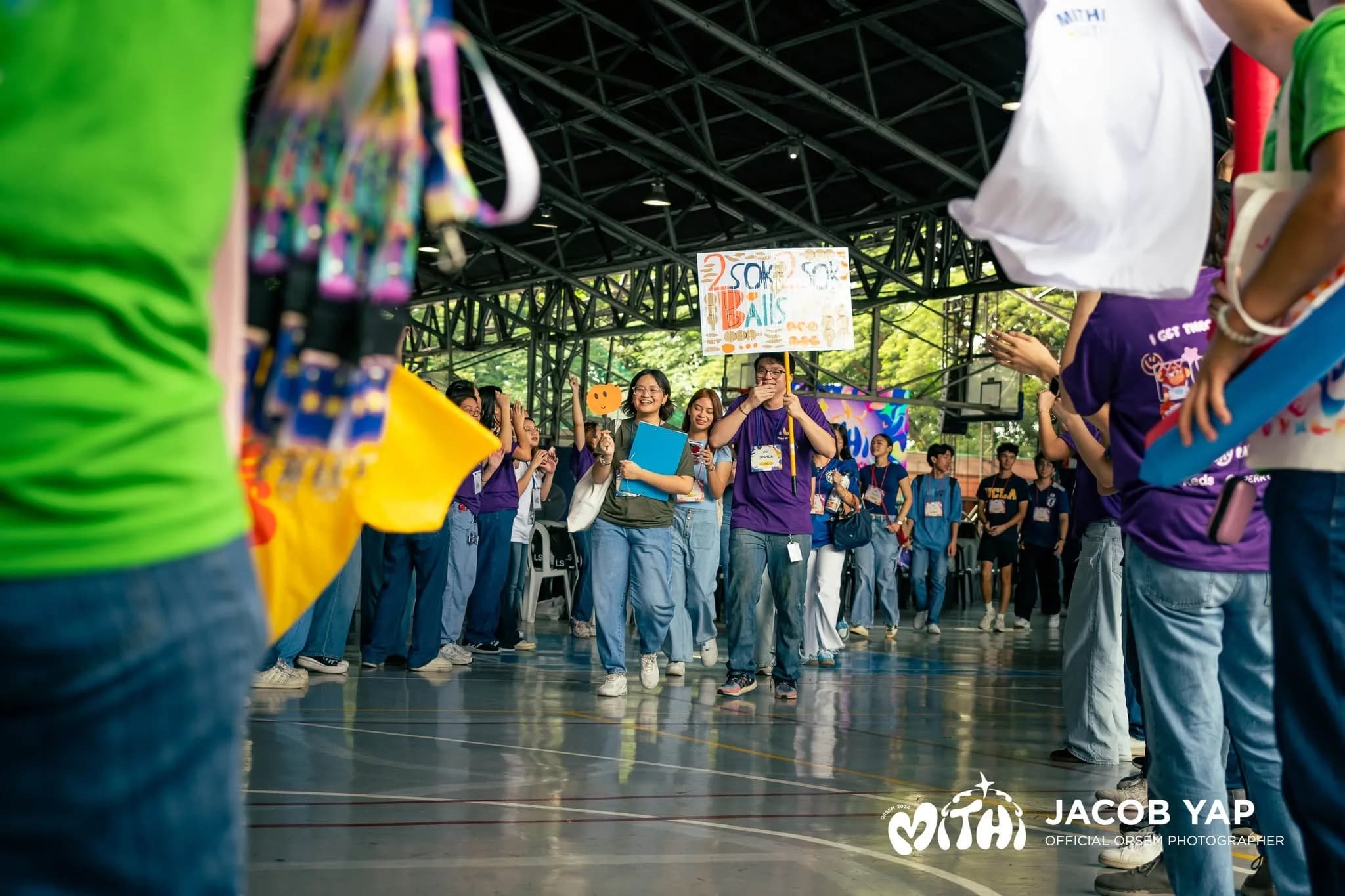 Freshmen walking through a cheering line of OrSem volunteers